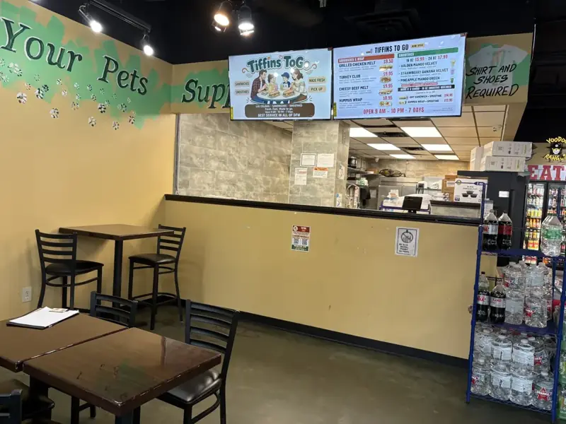 Side view of the Tiffins ToGo counter with the TV menu boards above it, inside Urban Center Market