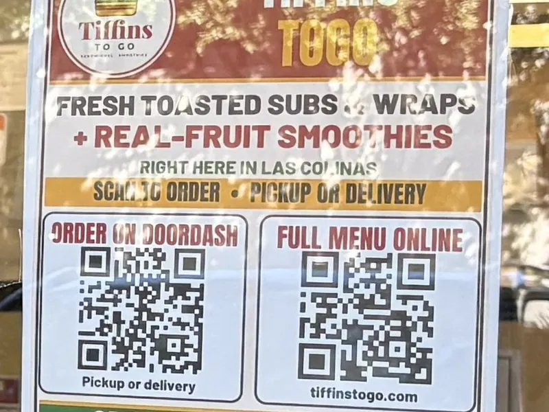Tiffins ToGo door flyer reading "Fresh toasted subs and wraps + real-fruit smoothies" with order QR codes