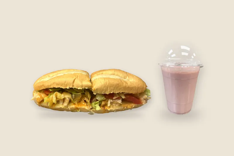 Sandwich + Smoothie Combo: a Grilled Chicken Melt on a toasted roll next to a Strawberry Banana Velvet smoothie in a domed cup