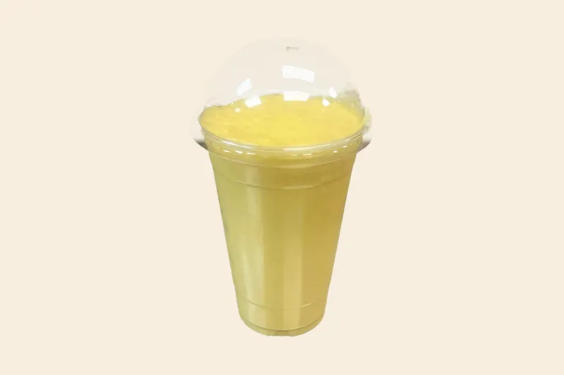 Golden Mango Velvet smoothie, bright yellow, in a clear domed cup