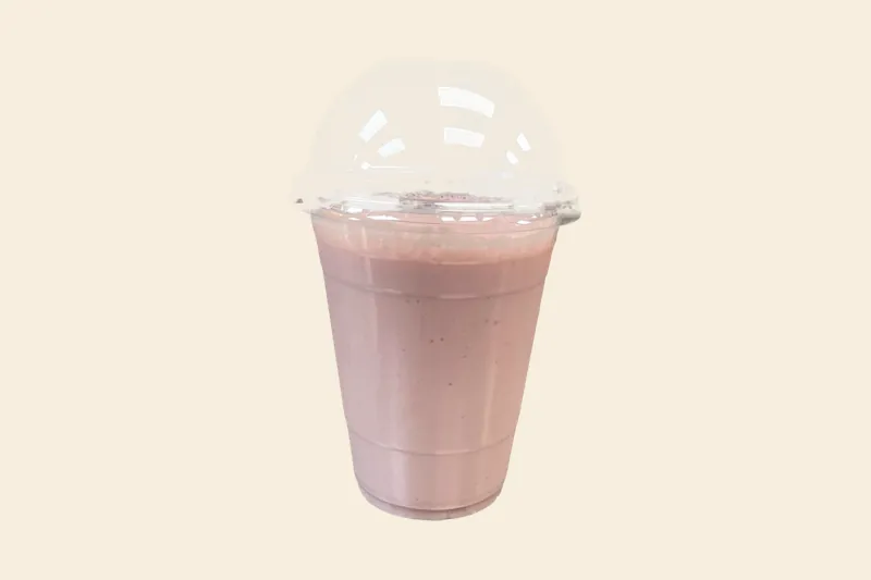 Strawberry Banana Velvet smoothie, pale pink, in a clear domed cup